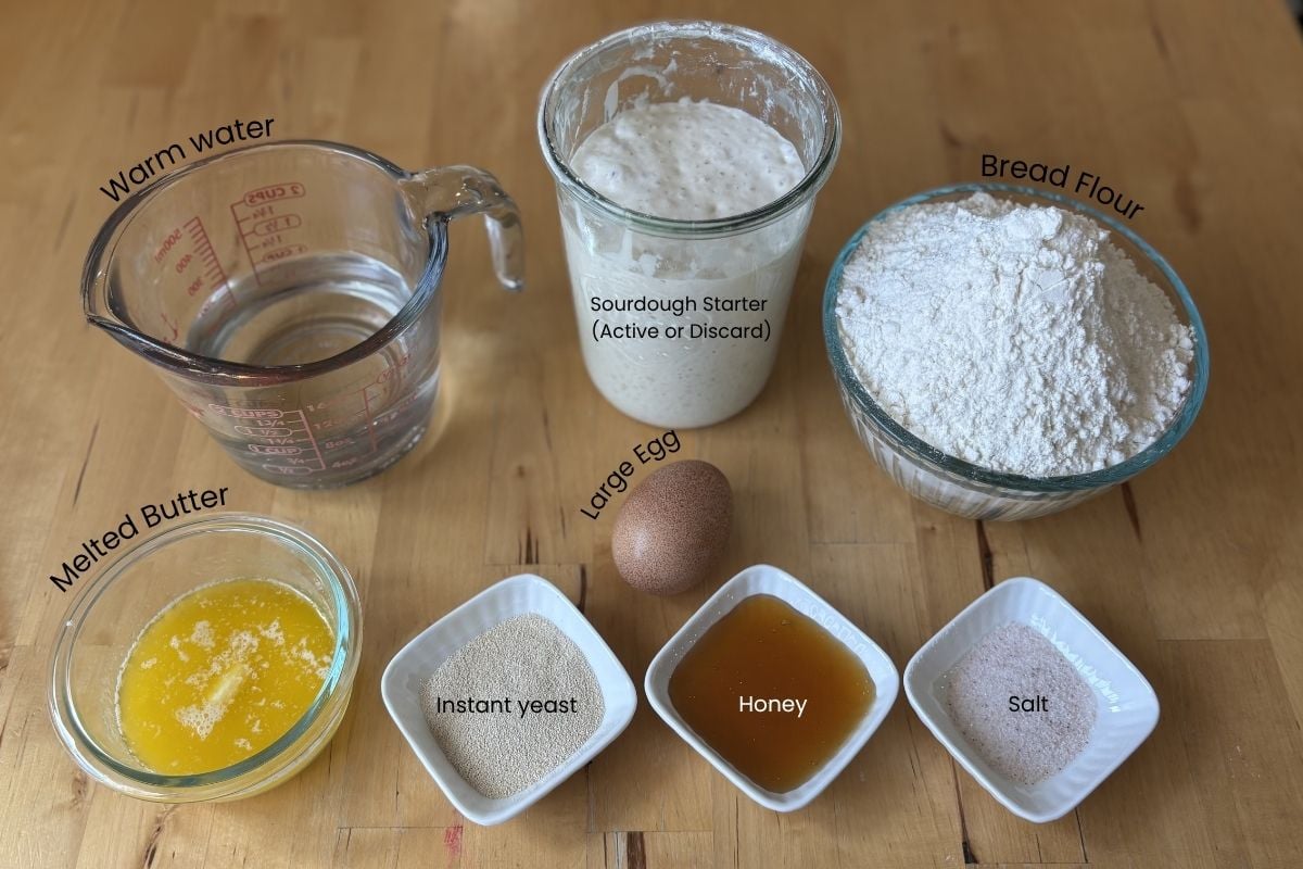 ingredients for Quick Sourdough Discard Dinner Rolls. Warm Water, Sourdough starter, bread flour, melted butter, yeast, honey, salt, egg. 